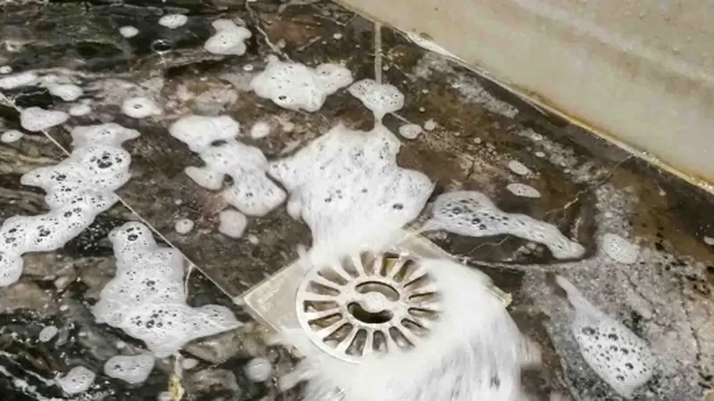 Ralo de piso entupido com água e espuma acumuladas