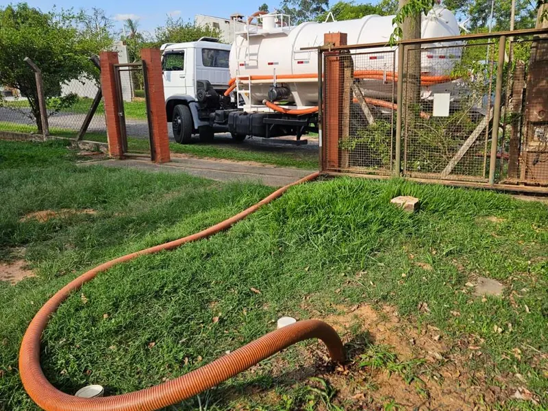 Caminhão de limpeza de fossa atendendo em área residencial