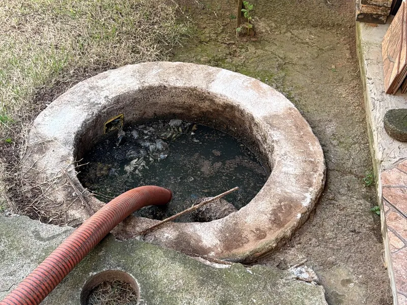 Esgotamento de fossa em quintal, com mangote de sucção
