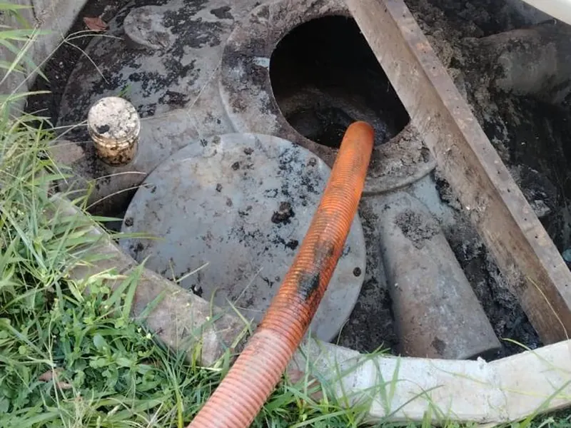 Fossa séptica aberta com mangote de sucção durante a limpeza