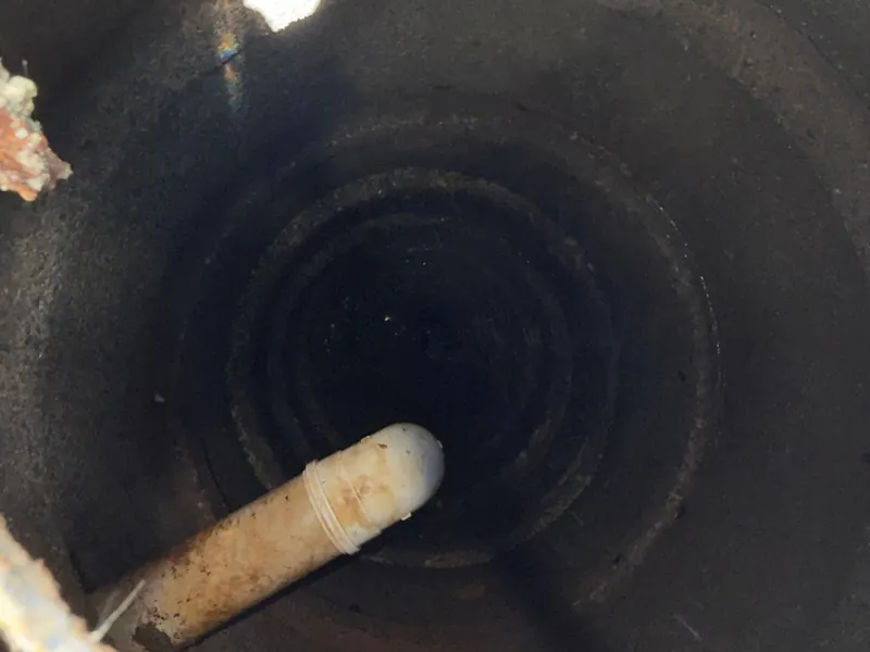 Interior da fossa durante o esgotamento, com o mangote de sucção
