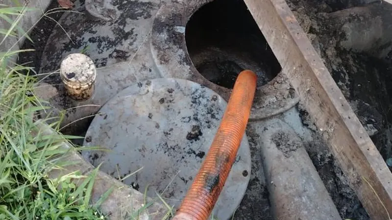 Fossa séptica aberta durante a limpeza, com mangote de sucção da Desentupidora Hidro Aqua